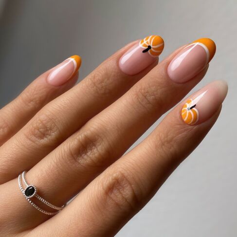 Orangefarbene French Nails mit einem Kürbismotiv